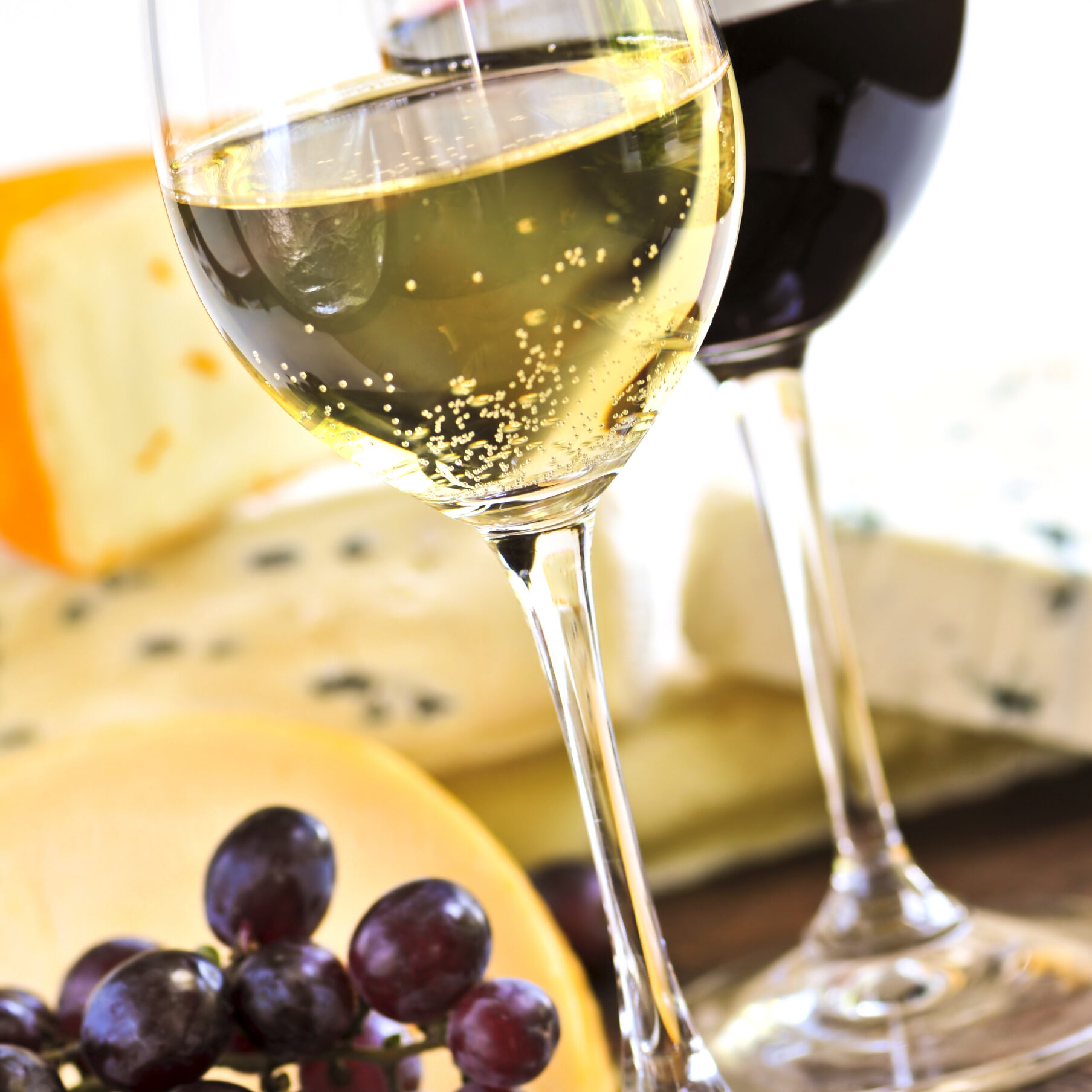 Wineglasses with red and white wine and assorted cheeses